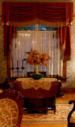 The windows peek from behind the curtains to reveal their leaded glass.