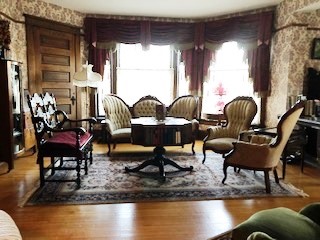 Reproduction furniture in the parlor matches the house perfectly.