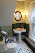 A private bath nestles under the back third-floor stairs, with a view of the carriage house from the window.