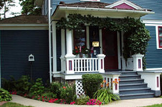 The vine-covered west porch is nestled in a well-established border bed.