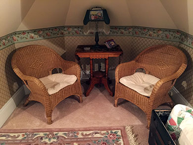 An antique dresser nestles between two antique leaded glass windows.